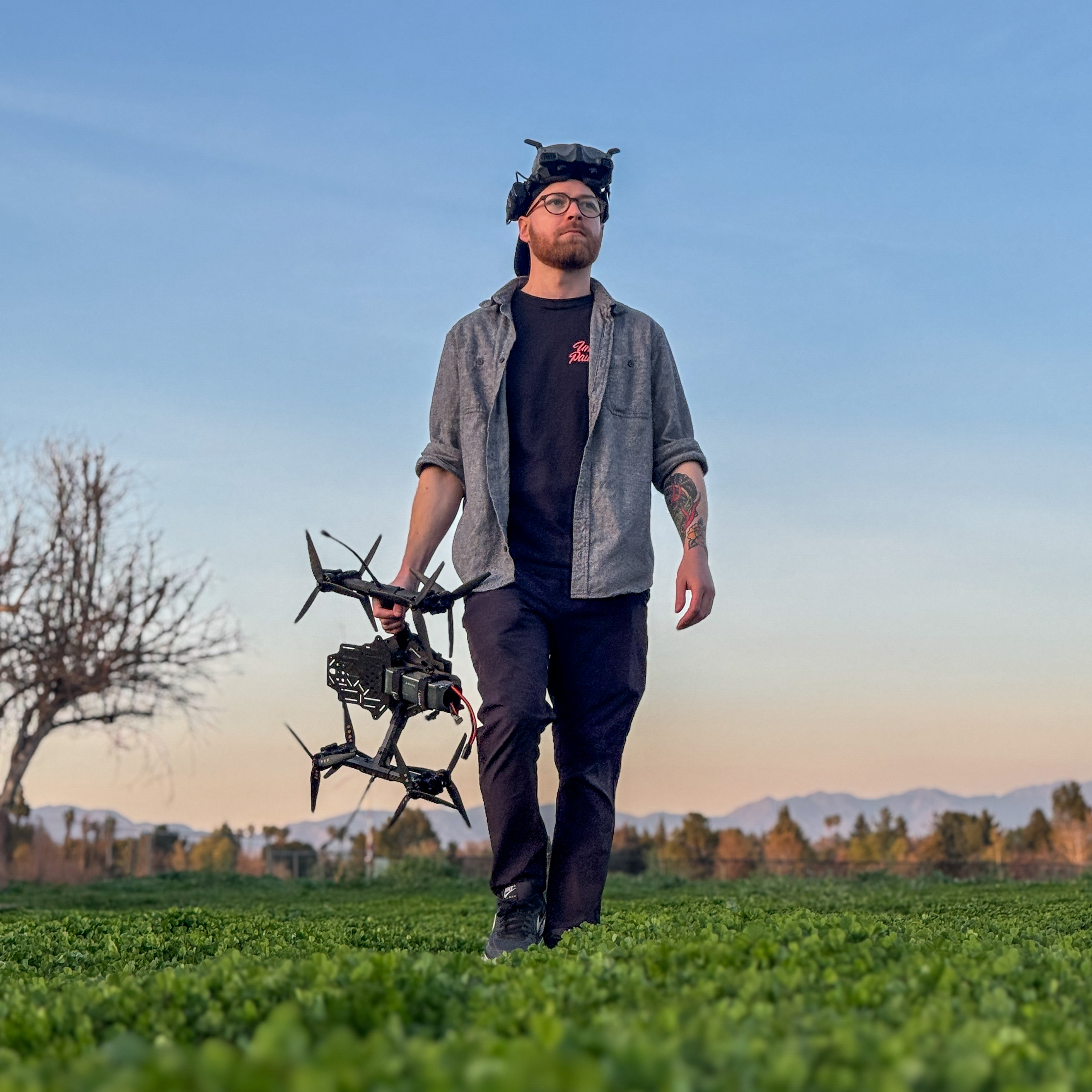 Zach with FPV drone in field at sunset